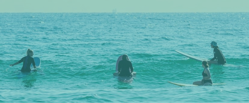 women on surfboards waiting for waves