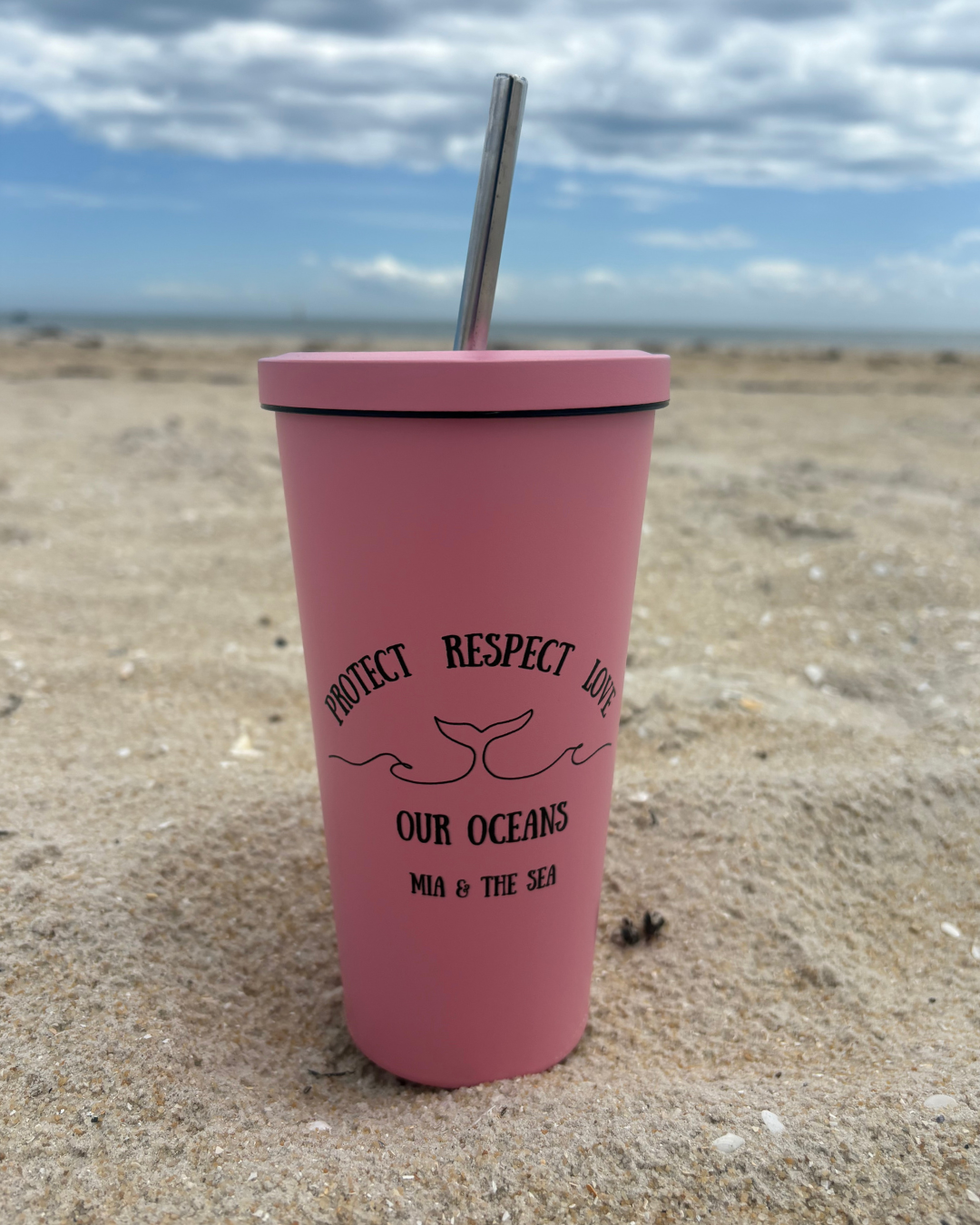 Pink tumbler with Protect Respect Love Logo on sandy beach